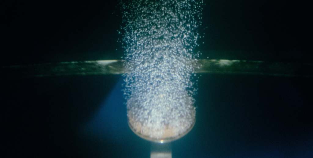 Un'inquadratura di una goccia d'acqua che esce da un tubo.